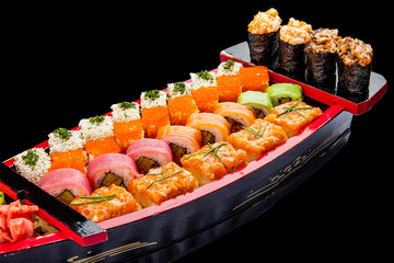 Sushi set in a wooden boat on a black background