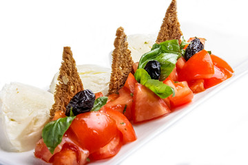 Caprese salad with croutons on white background. Traditional Italian dish.