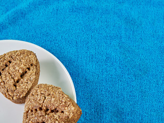 homemade breads from germinated wheat and rye Two pieces on a white plate in the corner of the frame on a blue towel. healthy food. copy space