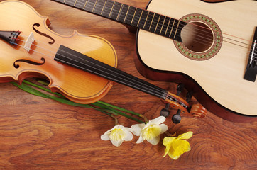 Acoustic guitar, violin and a bouquet of daffodils.