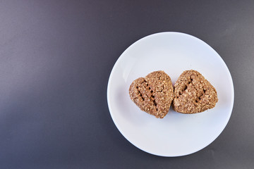 high quality dietary homemade bread two rolls on a white plate and a dark background. healthy food on the table. fresh bread. copy space. top view