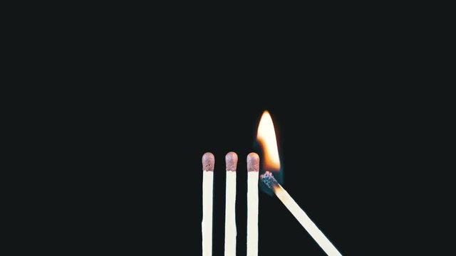 Three Matches are Lit a Flame on a Black Background and then goes out creating a Lot of Smoke