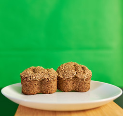 vegetarian bread made from germinated wheat and rye on a snow-white plate on a cutting bamboo board on a green background. healthy food.