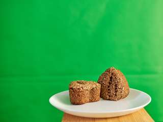 vegetarian bread made from germinated wheat on a snow-white plate on a cutting bamboo board on a green background. healthy food.