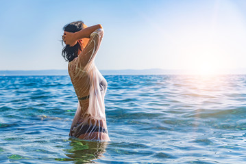 Happy woman enjoying beautiful sunset on the beach. © Tanya Rozhnovskaya