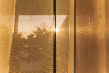 Curtains on window with sun. The sun shines through curtains