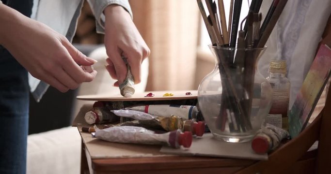 Female Artist Squeezing Paint From Tube