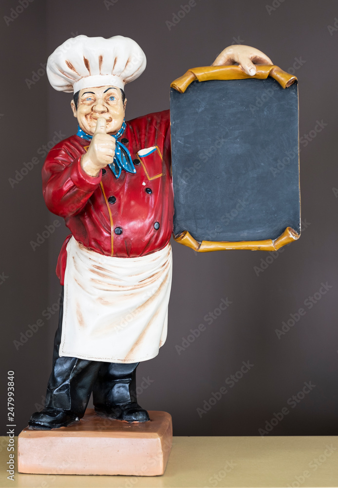 Wall mural decorative wooden cook with thumb up holding poster, dressed in typical chef clothing