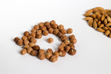  handful of nuts on a white background, almonds and hazelnuts, nest