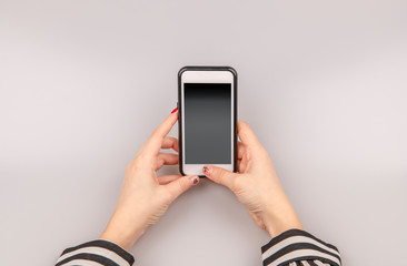 Woman holding in the hands phone with blank screen display 