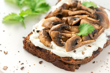 Toast with mushrooms and ricotta, closeup. Tasty breakfast.