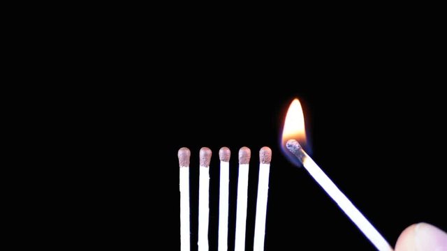 Chain Reaction of Five Matches Lit and Flame on a Black Background