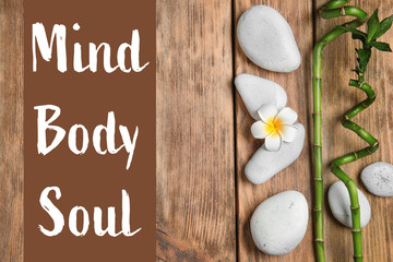 Flat lay composition with spa stones and space for text on wooden background