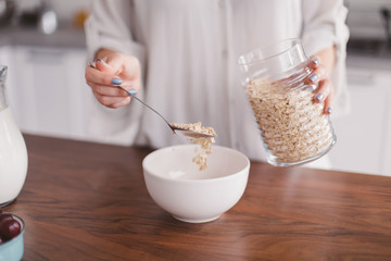 Beautiful young woman making breakfast in the kitchen