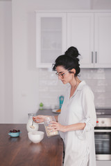 Beautiful young woman making breakfast in the kitchen