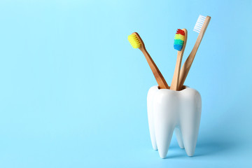 Tooth shaped holder with brushes on color background. Space for text
