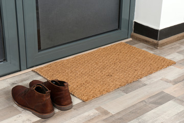 New clean mat and shoes near entrance door