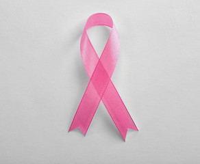 Pink ribbon on white background, top view. Breast cancer awareness concept