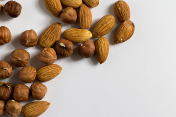  handful of nuts on a white background, almonds and hazelnuts