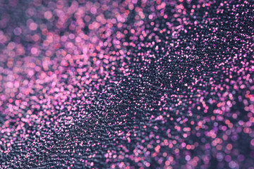 Pink glitter with bokeh effect on dark background