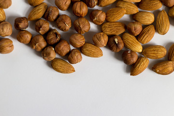  handful of nuts on a white background, almonds and hazelnuts