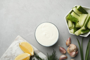 Flat lay composition with cucumber sauce and ingredients on grey background. Space for text
