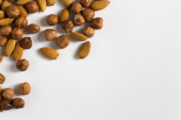  handful of nuts on a white background, almonds and hazelnuts