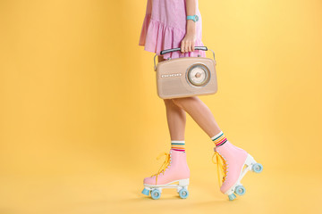 Young woman with roller skates and retro radio on color background, closeup. Space for text