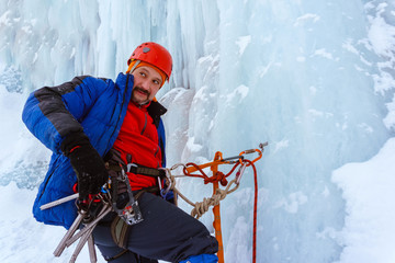 ice climber with a serious face on the wall of a glacier