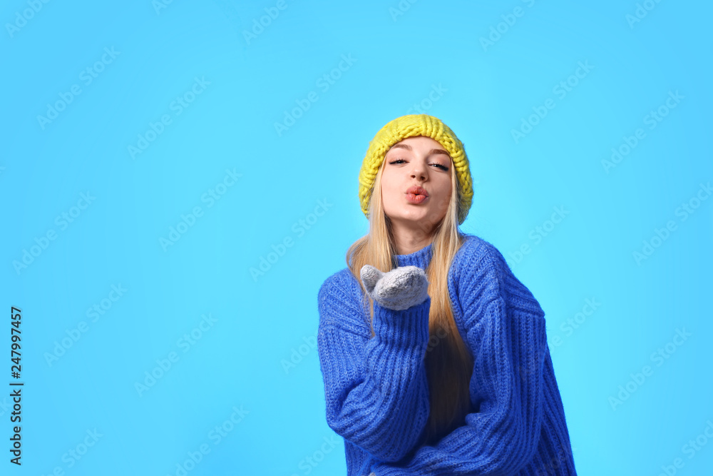 Sticker Portrait of emotional young woman in stylish hat, sweater and mittens on color background, space for text. Winter atmosphere