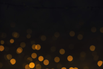 Beautiful golden lights on dark background. Bokeh effect