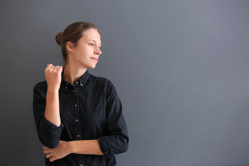 Beautiful young woman on grey background