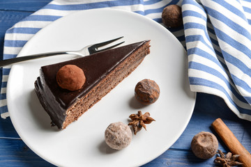 Plate with piece of tasty chocolate cake on table