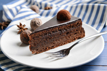 Plate with piece of tasty chocolate cake on table