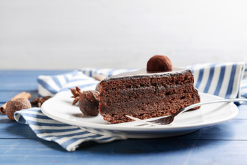 Plate with piece of tasty chocolate cake on table
