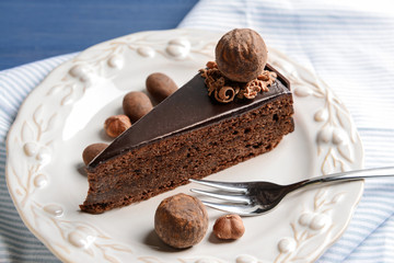 Plate with piece of tasty chocolate cake on table
