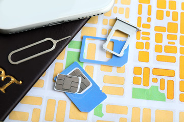 Sim cards with passport and mobile phone on map