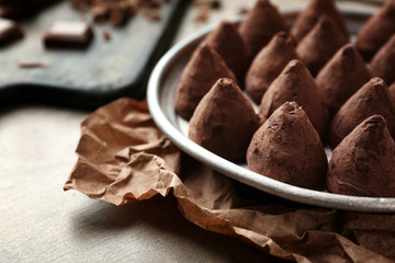 Plate with tasty sweet truffles on table, closeup