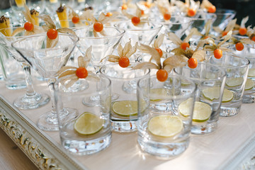 Many glasses of fruit prepared for lemonade.