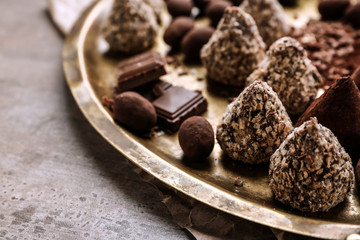 Tray with tasty sweet truffles on table, closeup