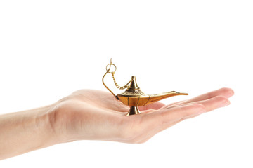 Female hand holding Aladdin lamp of wishes on white background