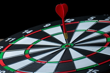 Close up shot red dart arrow on center of dartboard, metaphor to target success, winner concept, Isolated on white background with clipping path 