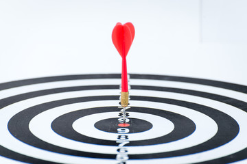 Fototapeta na wymiar Close up shot red dart arrow on center of dartboard, metaphor to target success, winner concept, Isolated on white background with clipping path 