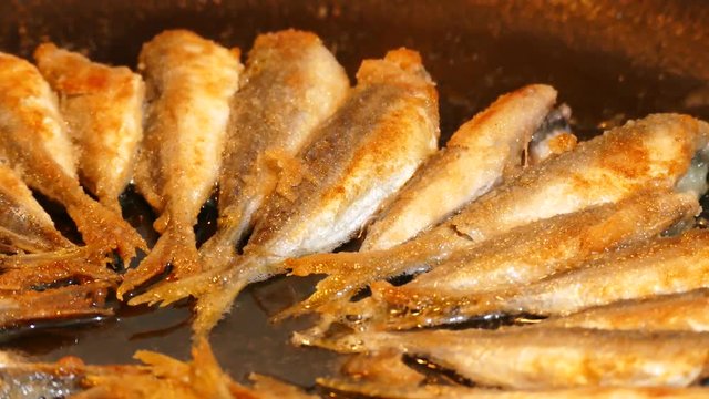 fish cooked in oil with pan, fishes cooked in the pan, close-up, fried fish,