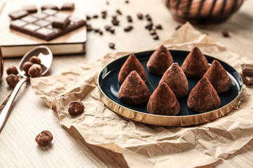 Plate with tasty sweet truffles on table
