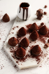 Board with tasty sweet truffles on white table