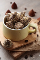 Boards with tasty sweet truffles in cup on table