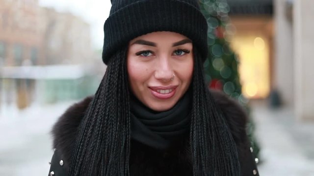 winter, christmas, people concept- Portrait of young woman looking at camera and smiling. outdoor closeup portrait of young beautiful calm stylish girl wearing cool knitted winter