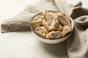 Bowl with tasty Italian biscotti on light table