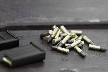 Small caliber cartridges for rifle and shops on wooden background